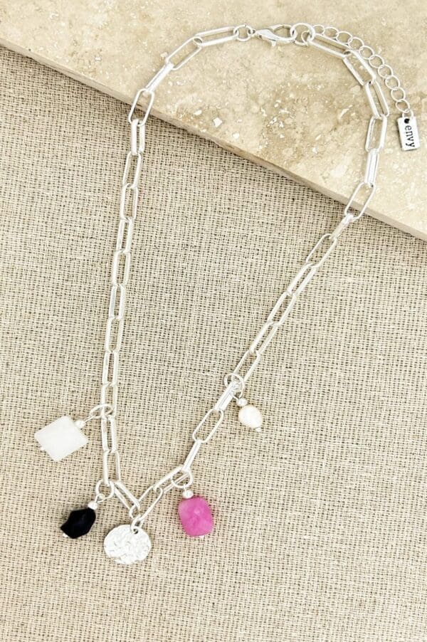 Short silver necklace with pink black and white charms